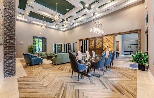 A room with a wooden floor and a long table with chairs.