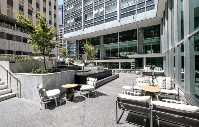 an outdoor patio with tables and chairs in front of an office building