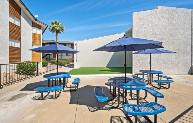 patio with blue tables and chairs and umbrellas