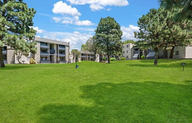 a large green lawn in front of some apartment buildings