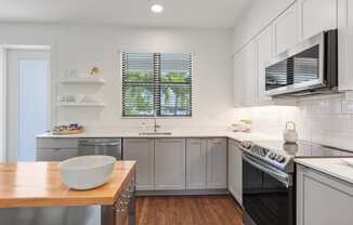 a kitchen with stainless steel appliances and a wooden table at Odyssey, Florida, 33905