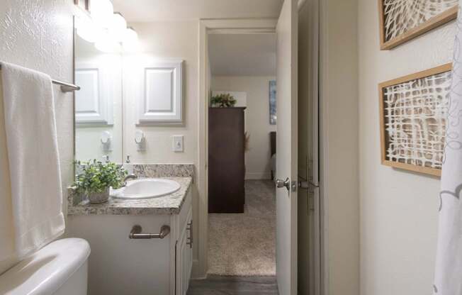 A bathroom with a white vanity and linen closet in a 1 bedroom, 1 bath 554 sq ft apartment home at The Biltmore Apartments located in the Vickery Midtown neighborhood of Dallas, TX.