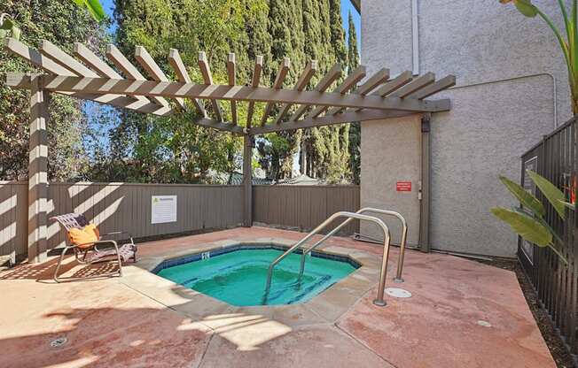 A small pool with a wooden pergola over it.