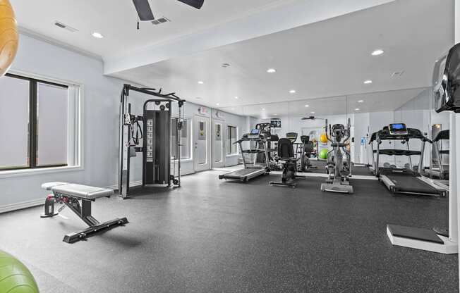 A spacious gym with a variety of equipment including treadmills, weights, and exercise machines.