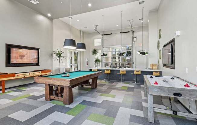 Game room with pool table and air hockey at GreenVue apartments in Richardson, TX