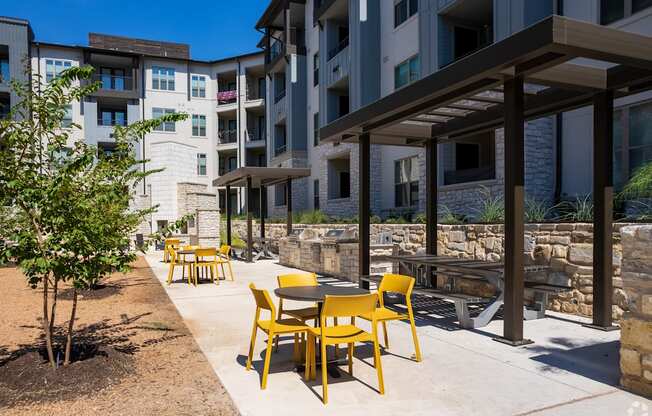 an outdoor patio with tables and chairs at an apartment complex