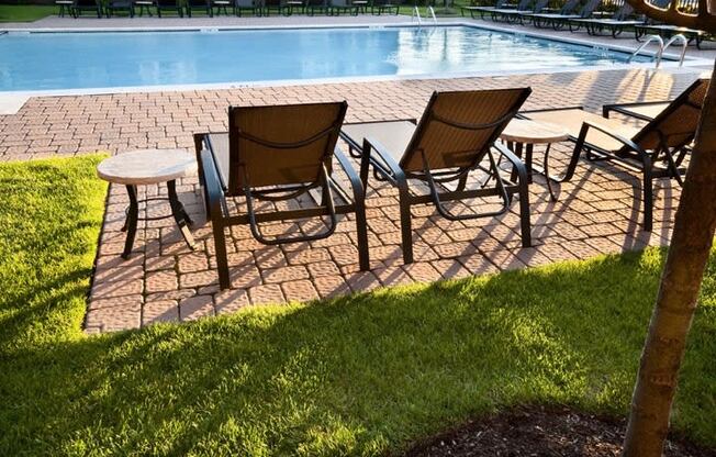 a patio with chairs and a pool in the background  at The Sheffield Englewood, New Jersey