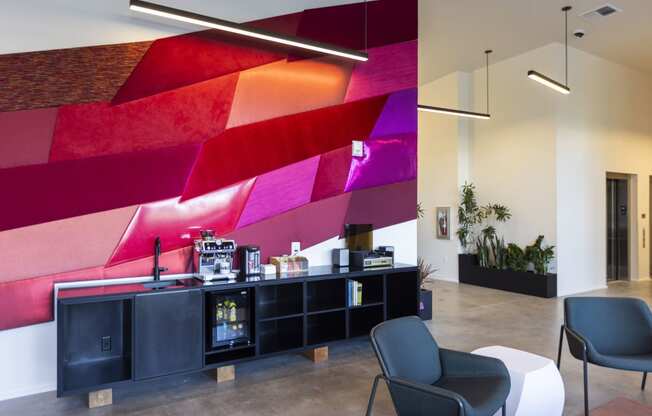 a lobby with a counter and chairs and a colorful wall at Analog PDX Apartments, Portland, OR