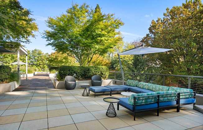 a terrace with couches and chairs and trees