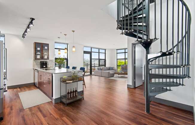 Living room with a spiral staircase and a kitchen with a sink and a counter at Equinox, Seattle, WA, 98102