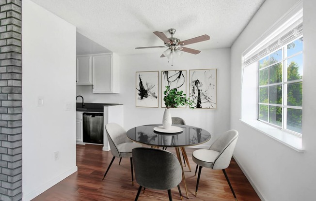 a dining room with a table and chairs and a ceiling fan