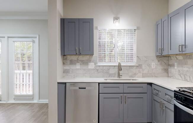 Renovated kitchen with grey cabinetry, stainless appliances