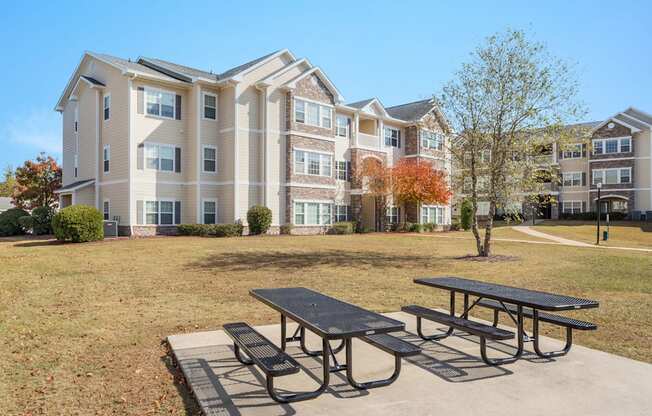 A large apartment complex with a picnic table in front.