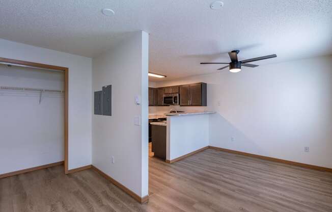 an empty living room and kitchen with a ceiling fan. Fargo, ND Sunwood Apartments
