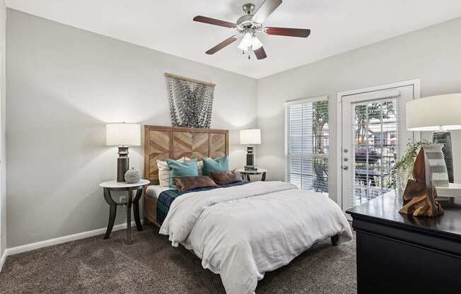 A bedroom with a large bed and a ceiling fan.