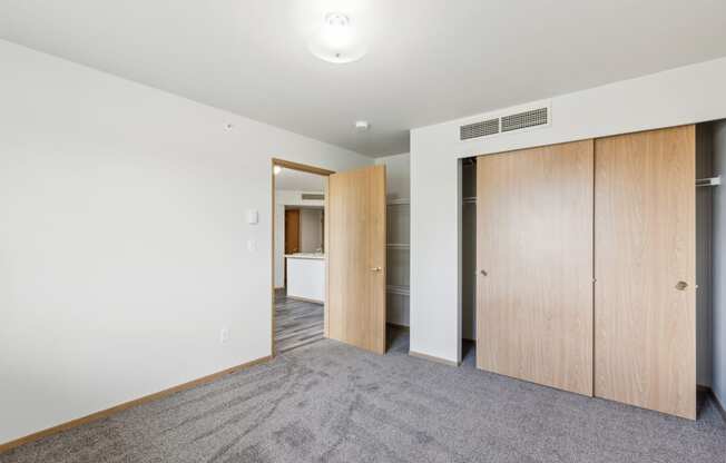 a living room with white walls and a door to a closet