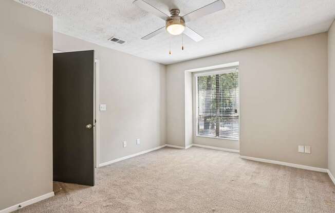 A room with a ceiling fan and a door.