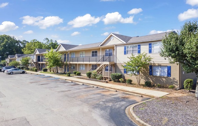 a street view of an apartment building with a parking lot