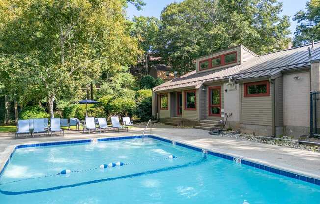 a swimming pool in front of a house with a pool