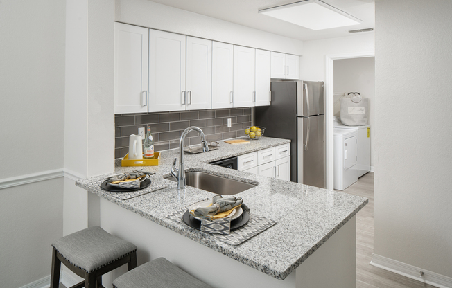 Model kitchen at our apartments in Tampa, featuring granite countertops and stainless steel appliances.