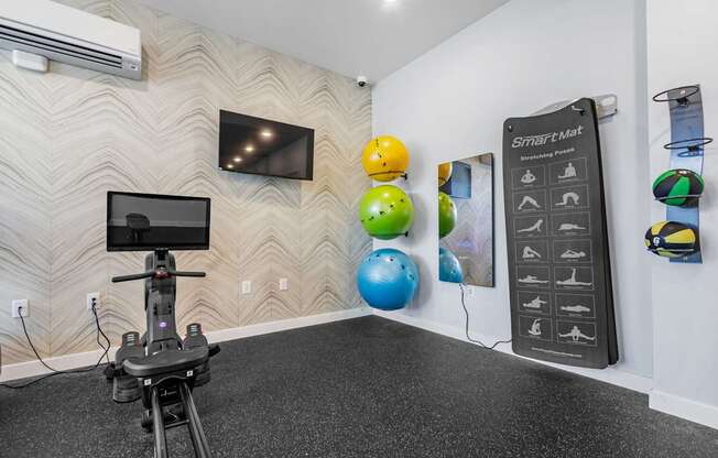 A room with a wall-mounted television, a Smart Mat, and a hoverboard.