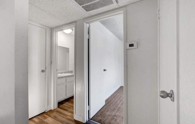 A hallway with a white door and a brown carpet.