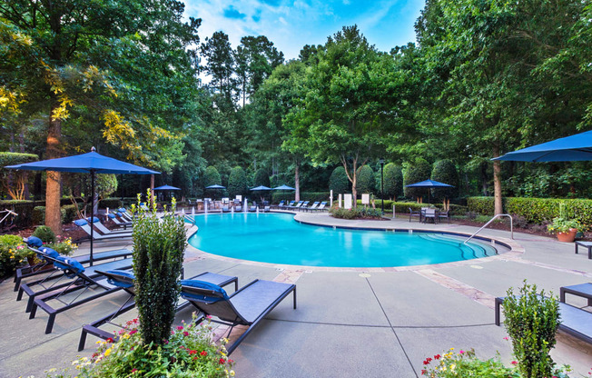 a swimming pool with chaise lounge chairs and umbrellas