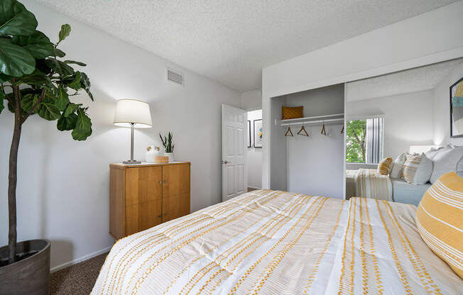 a bedroom with a yellow and white bedspread