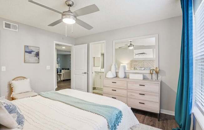 A bedroom with a bed, dresser, and mirror.