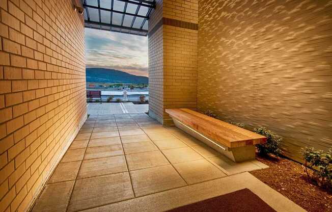 A long hallway with a bench and brick walls.