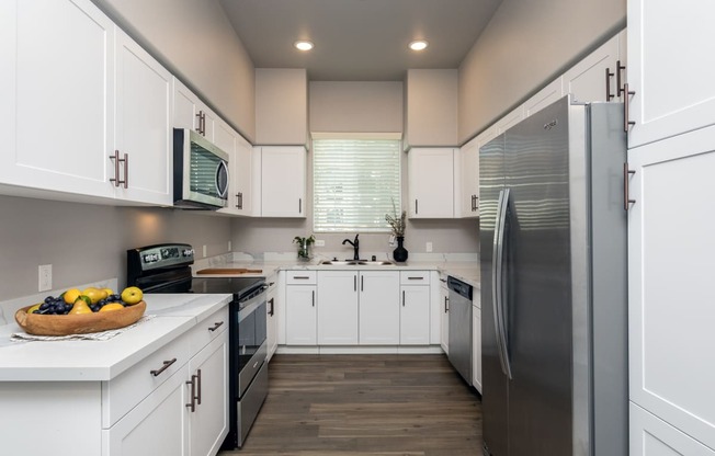 a kitchen with white cabinets and stainless steel appliances