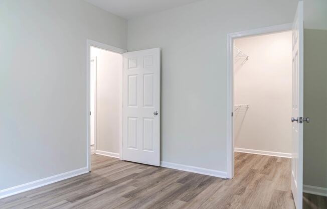a bedroom with an open door and a closet