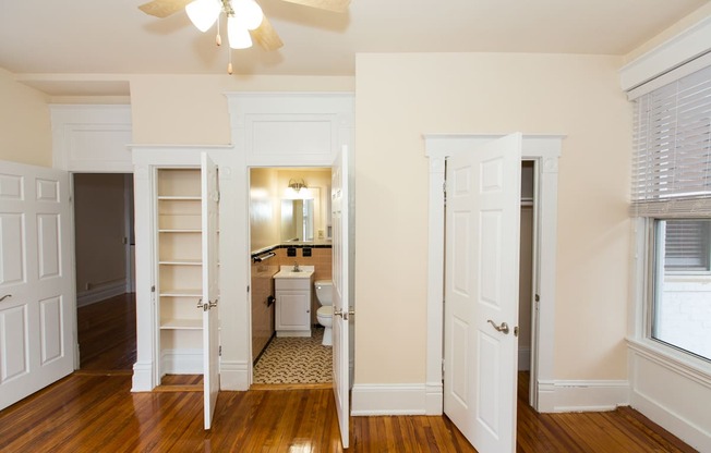 vacant bedroom with large windows, closet, ceiling fan and view of bathroom at dupont apartments in washington dc