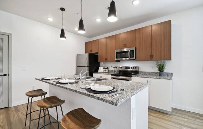 a kitchen with a granite counter at Gibson Oaks, Lakeland, 33809 top and a bar with stools