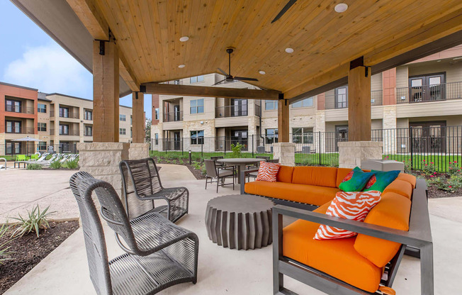 A patio with a table and chairs is surrounded by buildings.