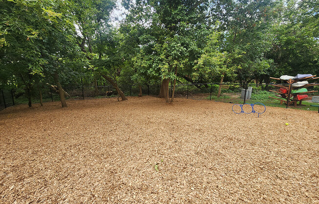 A bicycle is leaning against a tree in a field.