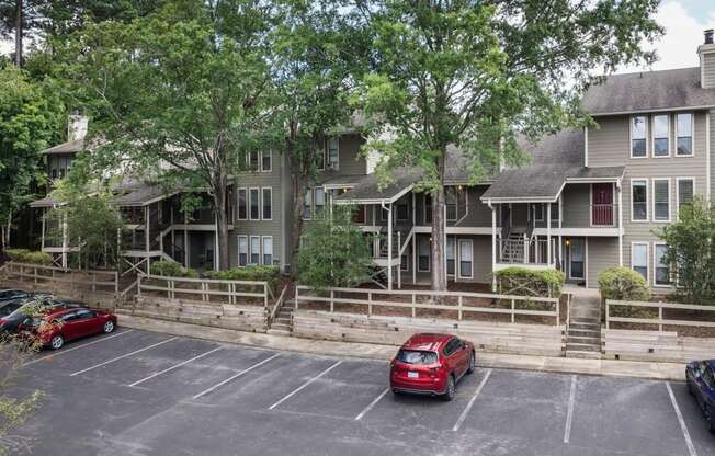 the apartment building with cars parked in a parking lot