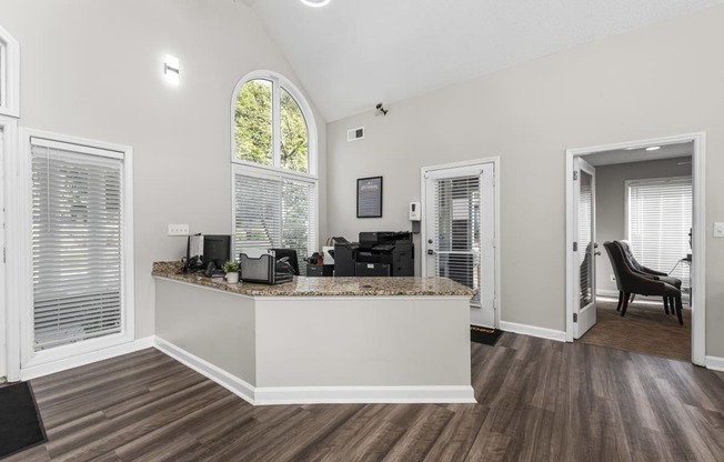 the living room and kitchen of a home with an arched window