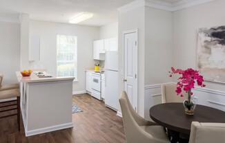 View of Dining Area, Showing Plank Wood Flooring, Dining Table, and View of Kitchen at Retreat at Peachtree City Apartments
