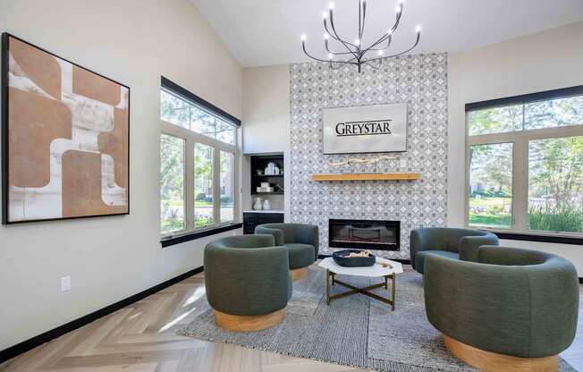 a living room with green chairs and a fireplace
