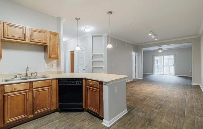 an empty kitchen with wooden cabinets and a black dishwasher