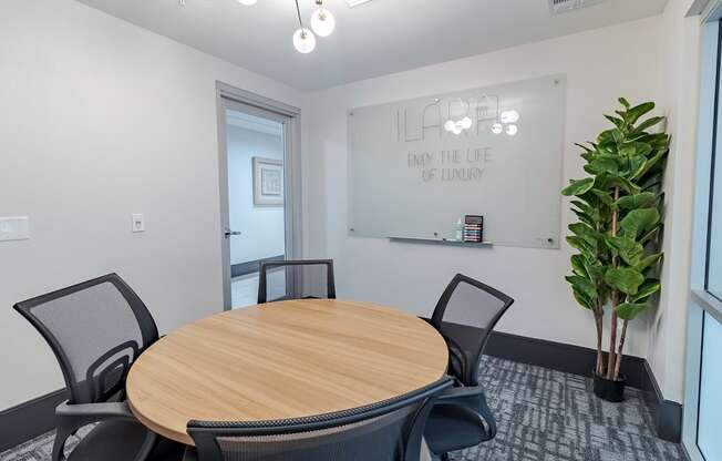 a conference room with a round table and a large potted plant