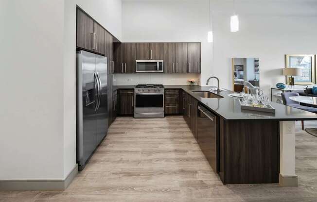 A modern kitchen with dark wood cabinets and a large island.