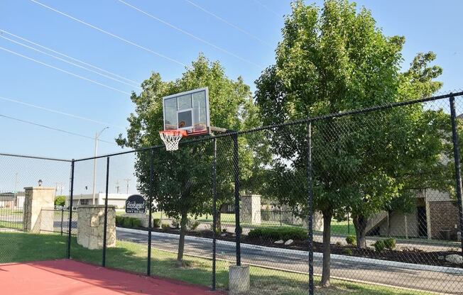 a basketball hoop on top of a chain link fence