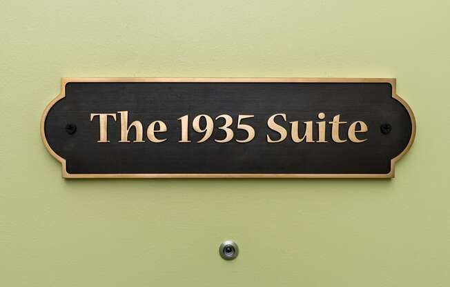 a black sign that reads the 1925 suite      on a green