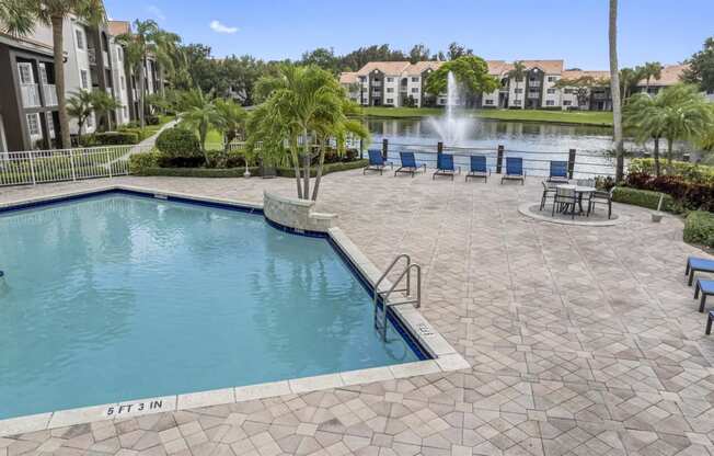 a large swimming pool with a fountain in front of a building