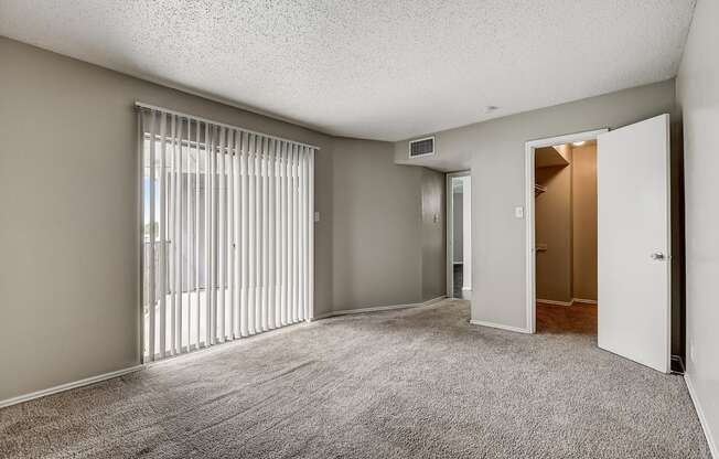 a bedroom with a sliding glass door and carpeted flooring