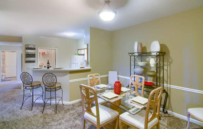 Enclave at Wolfchase Apartments in Cordova Tennessee photo of a dining room with a table and chairs and a kitchen in the background