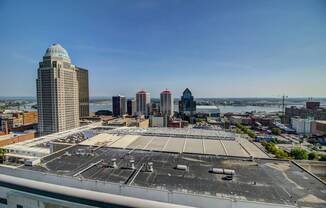A cityscape with a large open parking lot in the foreground.