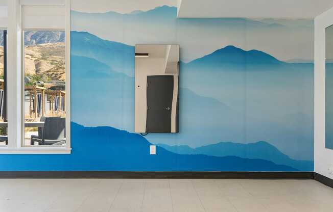 a blue wall with mountains painted on it and a door
